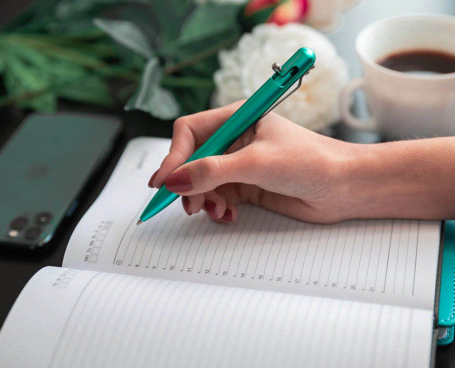 Writing in a notebook with a green Bastion pen